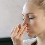 Caucasian woman practicing nadi shodhana pranayama for mindfulness and wellness indoors.